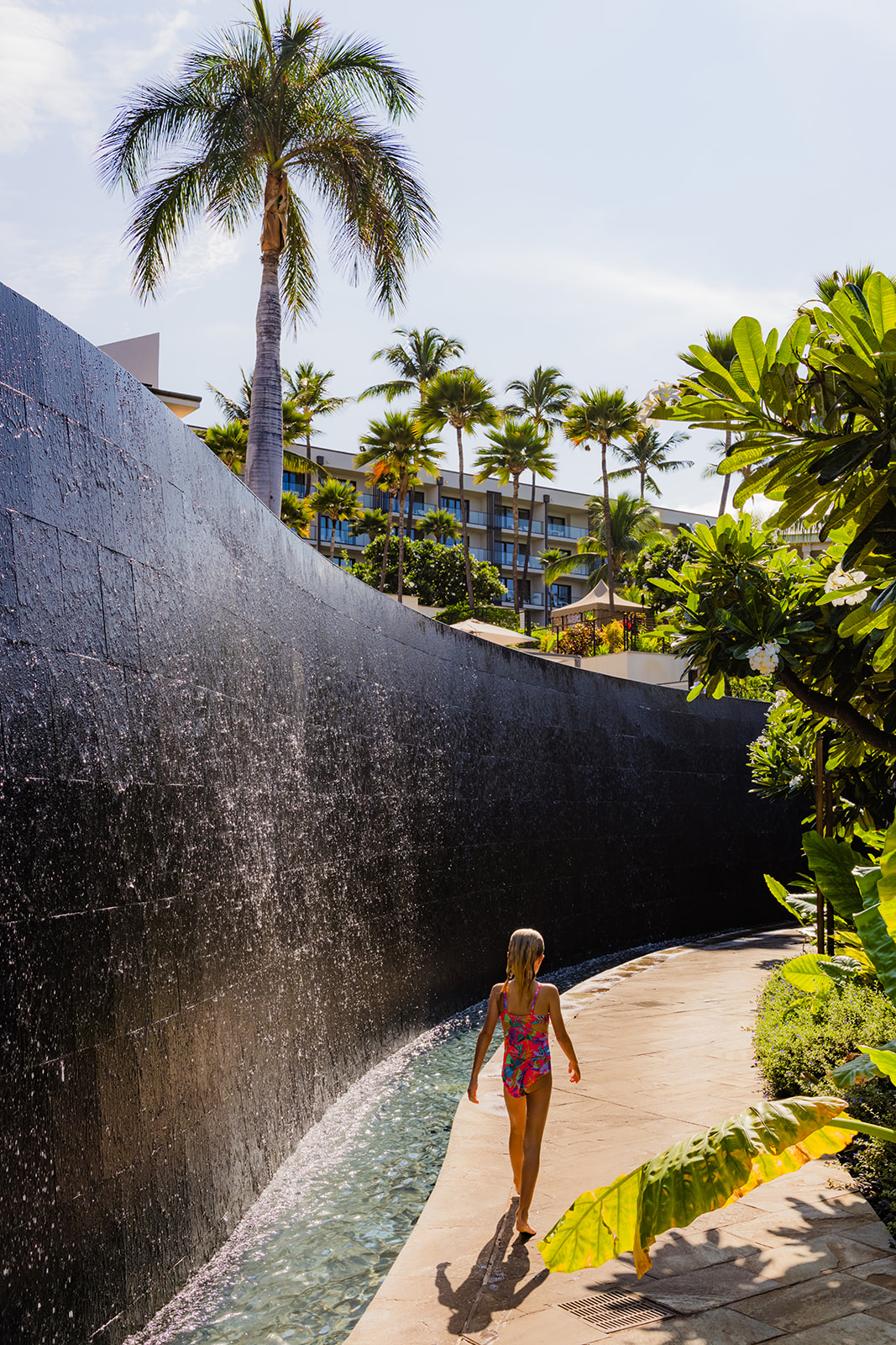 girl walks away from the camera while enjoying andaz maui at wailea resort pools