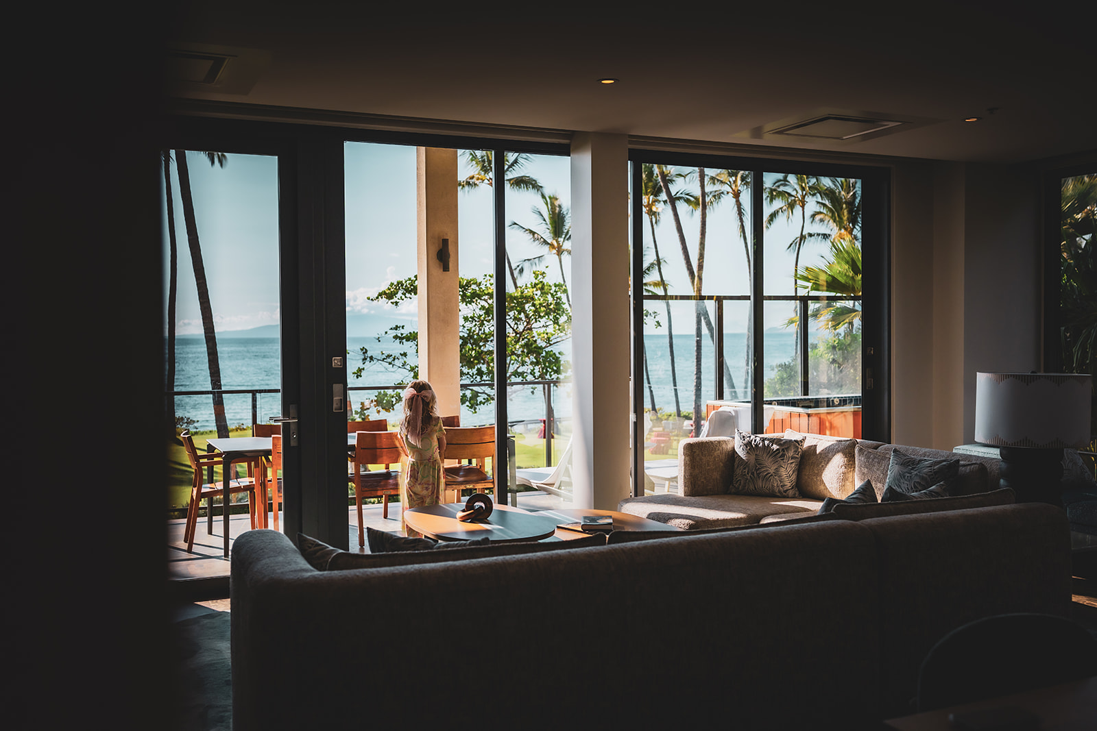 girl in pink bow looks outside the window wearing a coco moon hawaii jumpsuit