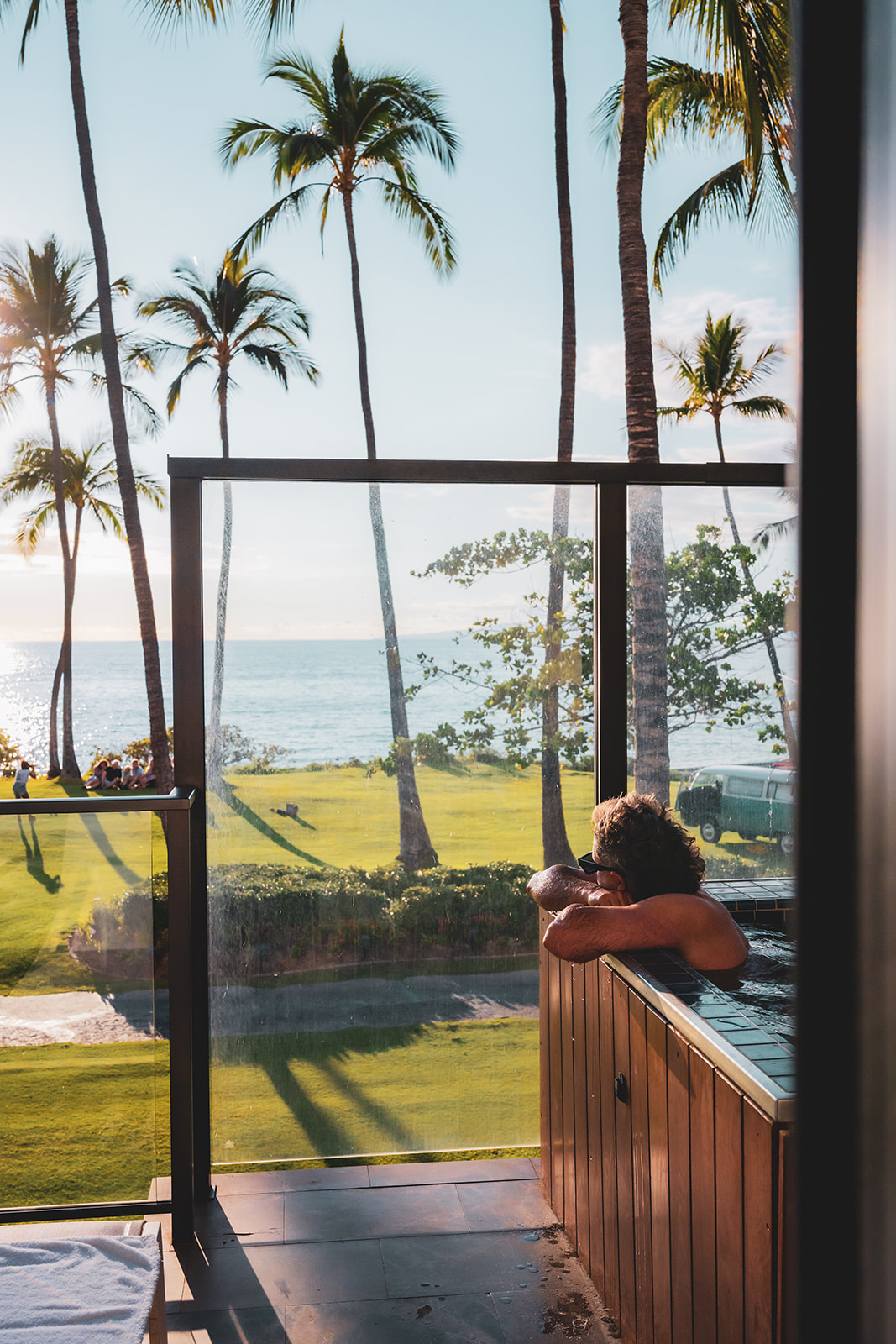 Man in jacuzzi at Makai Oceanfront Villa at Andaz Maui at Wailea resort wears black sunglasses and stares out to ocean